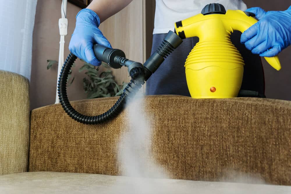 Worker in hi-vis washing a paved surface