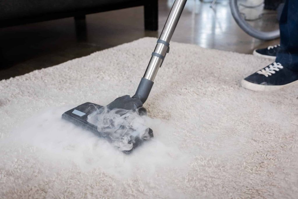 Crew member pressure washing a paved patio area