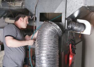 technician cleaning air duct