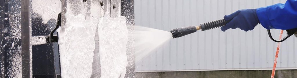 Washing down a commercial wall and floor mat area